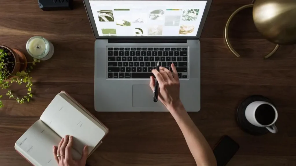 Laptop and notebook set out for online study at a table